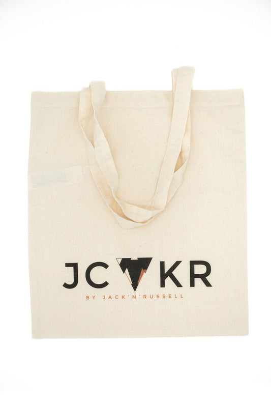 Beige tote bag with JCKR logo on a white background