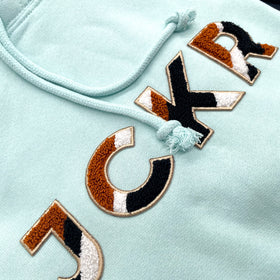 Glacial blue hoodie with JCKR chenille patch detail from up close