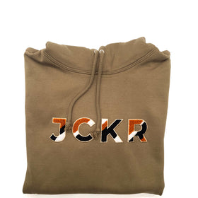 Folded dark beige hoodie with JCKR chenille patch on a white background