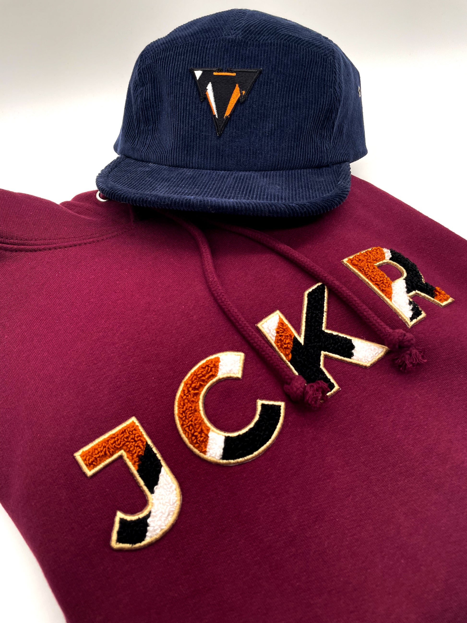 Navy blue corduroy cap and bordeaux hoodie with JCKR Chenille patch