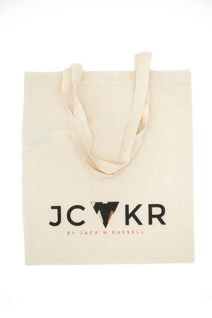 Beige tote bag with JCKR logo on a white background