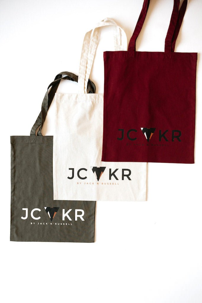 3 tote bags in different colors with the JCKR print on the front, organic cotton